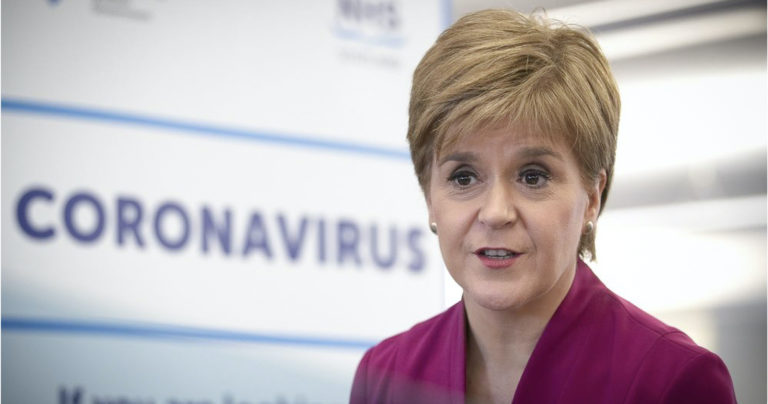First Minister of Scotland Nicola Sturgeon in front of a NHS Scotland Coronavirus sign